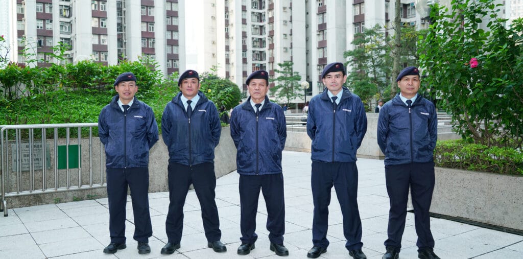 professional security guards in uniforms standing confidently in front of a residential building, ensuring safety and security for residents.