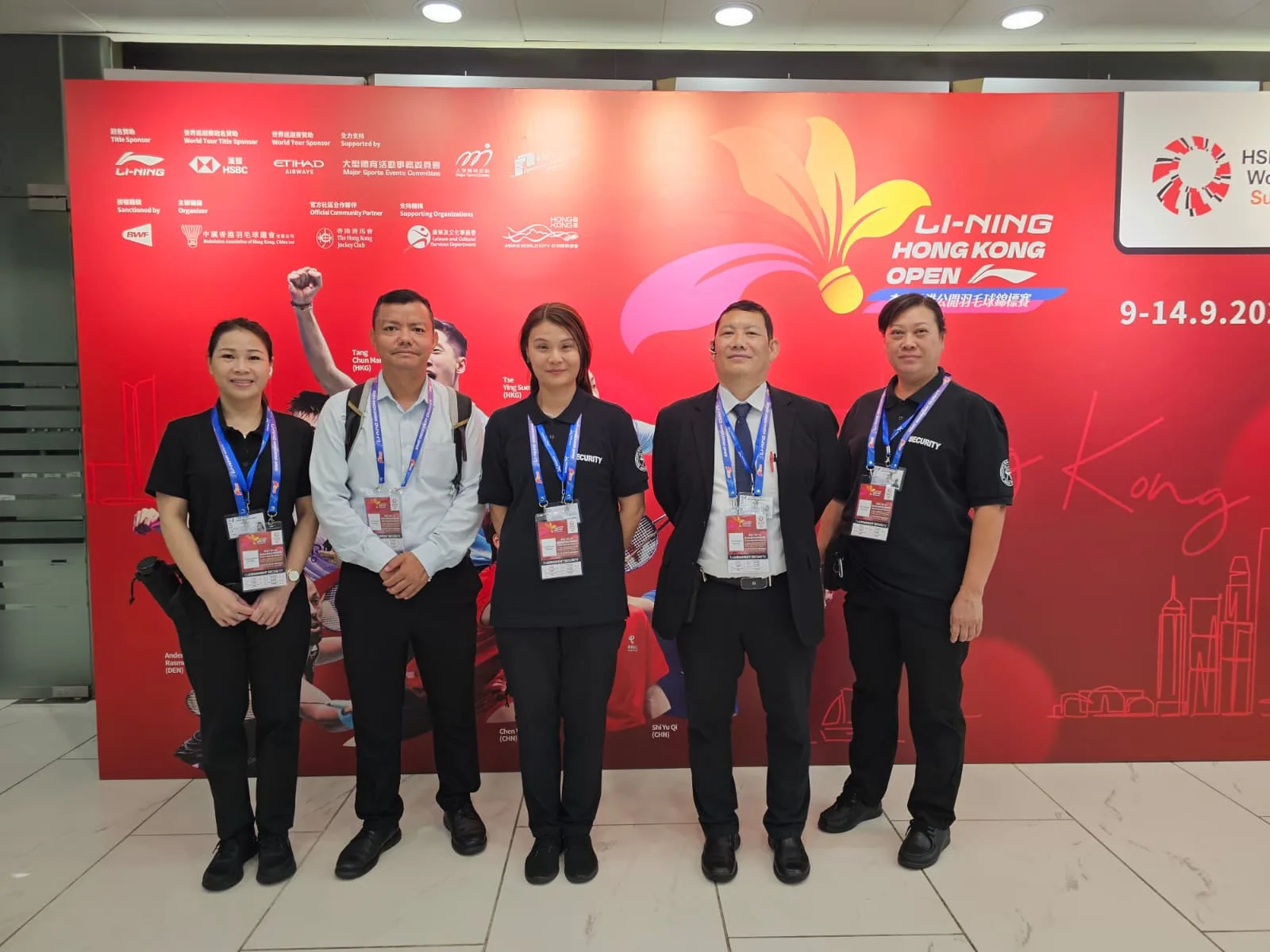 Security team staning infront of hong kong open poster
